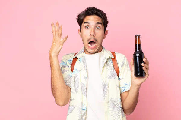 Молодой Латиноамериканец Кричит Поднятыми Руками Держит Бутылку Пива — стоковое фото