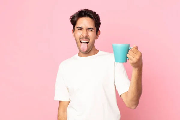 Молодой Латиноамериканец Веселым Бунтарским Отношением Шутя Высовывая Язык Держа Кофейную — стоковое фото