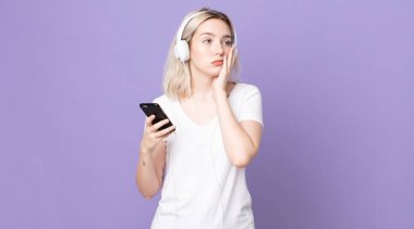 Genç, güzel albino kadın, kulaklıklar ve akıllı telefonlardan bıktıktan sonra sıkılmış, hayal kırıklığına uğramış ve uykulu hissediyor.