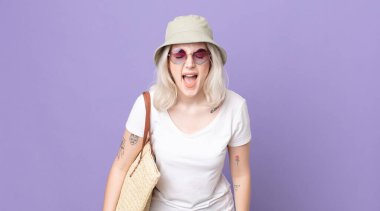 Genç, güzel, albino bir kadın agresif bir şekilde bağırıyor, çok kızgın görünüyor. yaz konsepti