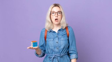 Genç, güzel bir albino kadın şok olmuş ya da şaşırmış görünüyor ve bir zeka oyunu çözüyor.