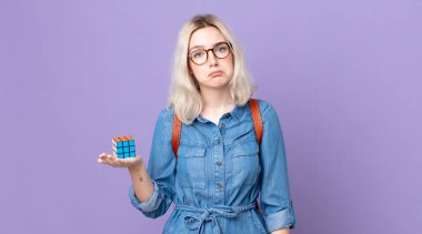 Genç ve güzel albino kadın üzgün ve sızlanıyor. Mutsuz bir bakışla, ağlayarak ve bir istihbarat oyununu çözerek.