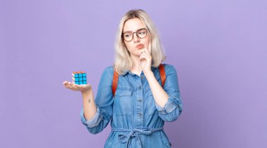 Genç, güzel albino kadın düşünüyor, kuşkucu ve şaşkın hissediyor ve bir zeka oyunu çözüyor.