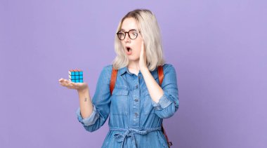 Genç, güzel albino kadın mutlu, heyecanlı ve şaşırmış hissediyor ve bir zeka oyunu çözüyor.