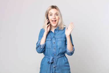 Genç, güzel, albino bir kadın kendini mutlu ve şaşkın hissediyor. İnanılmaz bir şey ve akıllı bir telefonla konuşuyor.