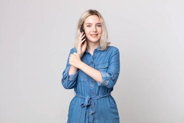 Genç ve güzel albino kadın mutlu hissediyor ve bir meydan okumayla yüzleşiyor ya da akıllı bir telefonla kutluyor ve konuşuyor.