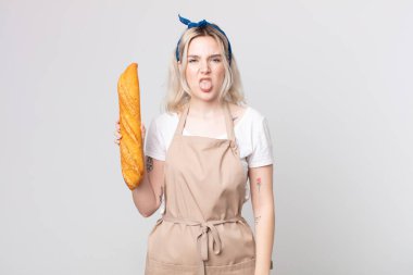 Genç, güzel, albino bir kadın. Tiksinmiş ve rahatsız olmuş hissediyor. Dilini ekmek ekmeğiyle çıkarıyor.