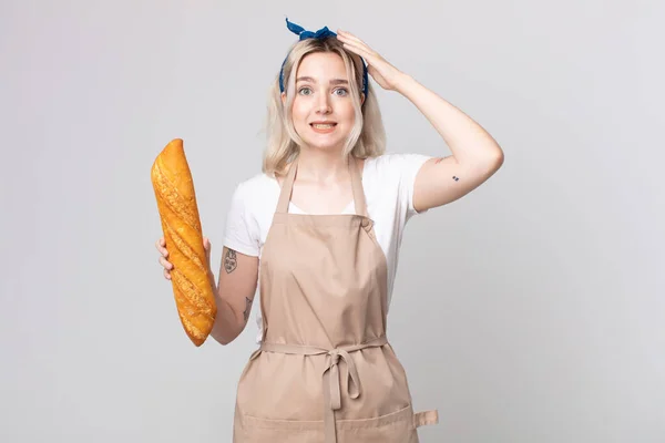 年轻漂亮的白化病妇女感到紧张 焦虑或害怕 双手放在头上 手里拿着面包面包面包 — 图库照片