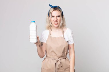 Genç, güzel, albino bir kadın tiksinmiş ve sinirlenmiş hissediyor ve bir şişe sütle dilini dışarı çıkarıyor.