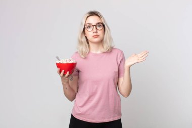 Genç, güzel albino kadın kafası karışmış ve kahvaltı kâsesiyle kuşkulanıyor.