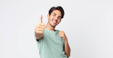 Hispanik yakışıklı adam gururlu, kaygısız, kendinden emin ve mutlu, olumlu gülümsüyor.