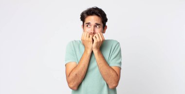 İspanyol yakışıklı adam endişeli, endişeli, stresli ve korkmuş görünüyor, tırnak yiyor ve yanal fotokopi alanı arıyor.