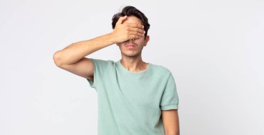 İspanyol yakışıklı bir adam tek eliyle gözlerini kapatıyor korkmuş ya da endişeli hissediyor, merak ediyor ya da körü körüne bir sürpriz bekliyor.