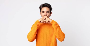 İspanyol yakışıklı adam ciddi görünüyor ve iki parmağının önde olması hoşnutsuzca reddedilerek sessizlik istiyor.