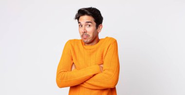 İspanyol yakışıklı adam omuz silkiyor, kafası karışık ve emin değil, kolları bağlı ve şaşkın görünüyor.
