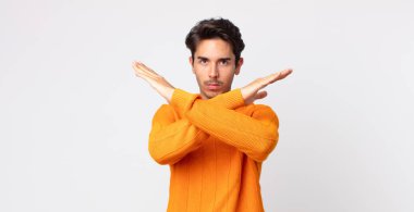 Hispanik yakışıklı adam senin tavırlarından rahatsız ve bıkkın görünüyor, yeter artık! Eller önde çapraz, durmanı söylüyor.