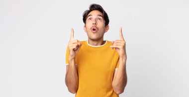 Hispanik yakışıklı adam huşu içinde ve ağzı açık. Şok olmuş ve şaşırmış bir bakışla yukarıya bakıyor.