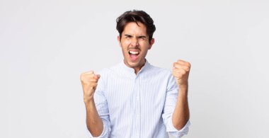 İspanyol yakışıklı adam mutlu, pozitif ve başarılı hissediyor, zaferi, başarıları veya iyi şansı kutluyor.