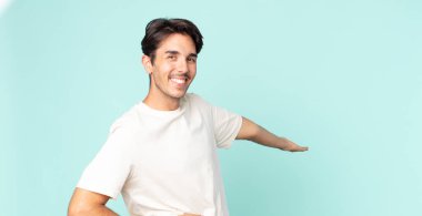 İspanyol yakışıklı adam kendini mutlu ve neşeli hissediyor, gülümsüyor ve seni hoş karşılıyor, dostça bir jestle içeri davet ediyor.