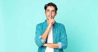 İspanyol yakışıklı adam ciddi görünüyor ve parmaklarını dudaklarına bastırıp sessizlik ya da sessizlik talep ediyor, sır saklıyor.