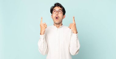 İspanyol yakışıklı adam şaşırmış, şaşırmış ve ağzı açık bir şekilde iki elini havaya kaldırıp uzayı kopyalamaya çalışıyor.