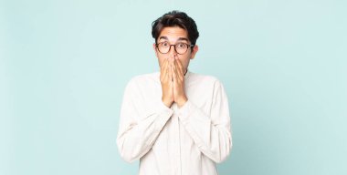 İspanyol yakışıklı adam mutlu ve heyecanlı, şaşırmış ve şaşırmış elleri ağızda, tatlı bir ifadeyle kıkırdıyor.