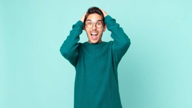 İspanyol yakışıklı adam el ele tutuşuyor, ağzı açık, son derece şanslı, şaşırmış, heyecanlı ve mutlu.