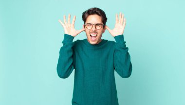 İspanyol yakışıklı adam panik ya da öfke içinde bağırıyor, şok olmuş, korkmuş ya da öfkeli, elleri başının yanında.