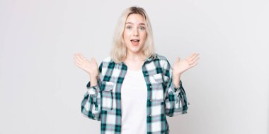 Güzel albino kadın mutlu, heyecanlı, şaşırmış ya da şok olmuş hissediyor, gülümsüyor ve hayrete düşüyor.