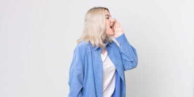 Güzel albino kadın profil görüntüsü, mutlu ve heyecanlı görünüyor, bağırıyor ve kenardaki boşluğu kopyalamak için arıyor