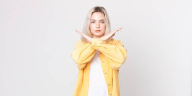 Güzel albino kadın senin tavırlarından rahatsız ve bıkkın görünüyor, yeter! Eller önde çapraz, durmanı söylüyor.