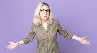 pretty albino woman feeling clueless and confused, having no idea, absolutely puzzled with a dumb or foolish look