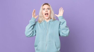 Güzel albino kadın elleri havada bağırıyor, öfkeli, sinirli, stresli ve üzgün.