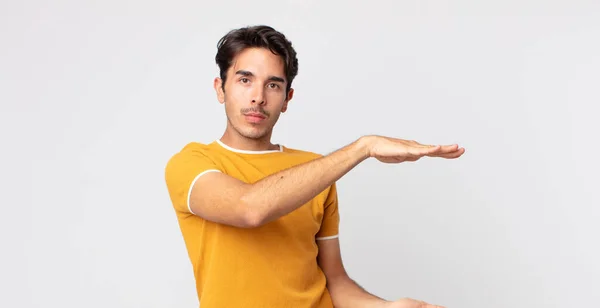 Hombre Guapo Hispano Sosteniendo Objeto Con Ambas Manos Espacio Copia — Foto de Stock