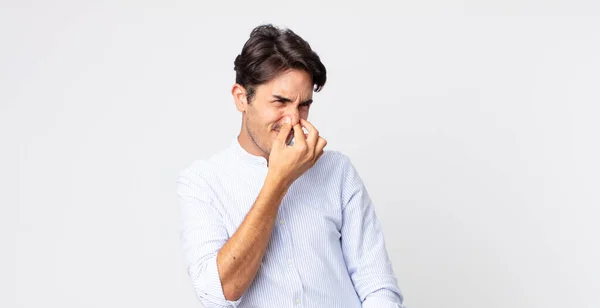Hispânico Bonito Homem Sentindo Enojado Segurando Nariz Para Evitar Cheirar — Fotografia de Stock