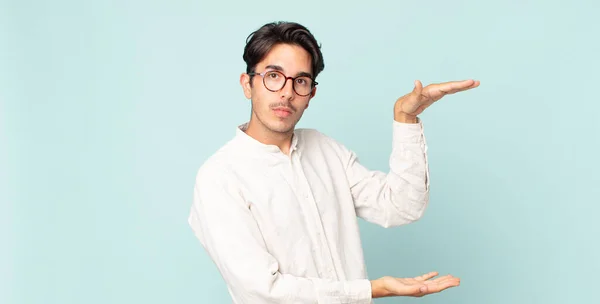 Hispanische Gutaussehende Mann Hält Ein Objekt Mit Beiden Händen Auf — Stockfoto