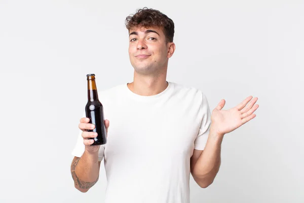 Jovem Homem Bonito Sentindo Intrigado Confuso Duvidar Segurando Uma Garrafa — Fotografia de Stock