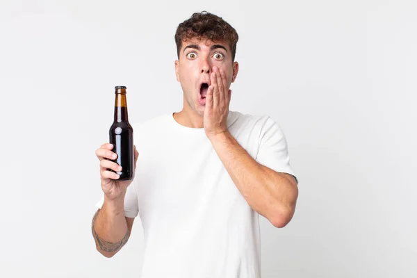 Joven Hombre Guapo Sintiéndose Sorprendido Asustado Sosteniendo Una Botella Cerveza — Foto de Stock