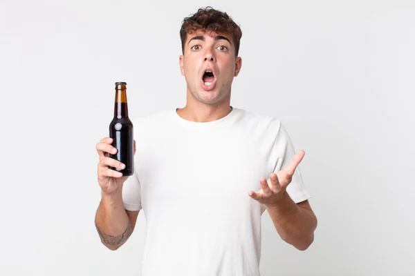 Young Handsome Man Feeling Extremely Shocked Surprised Holding Beer Bottle — Stock Photo, Image