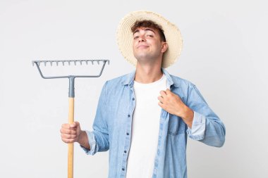 Genç yakışıklı adam kibirli, başarılı, pozitif ve gururlu görünüyor. çiftçi kavramı