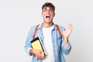 Genç yakışıklı adam kendini mutlu hissediyor ve inanılmaz bir şeye hayret ediyor. Üniversite öğrencisi konsepti