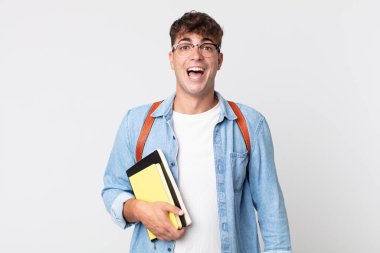 Genç yakışıklı adam mutlu ve hoş bir şekilde şaşırmış görünüyor. Üniversite öğrencisi konsepti