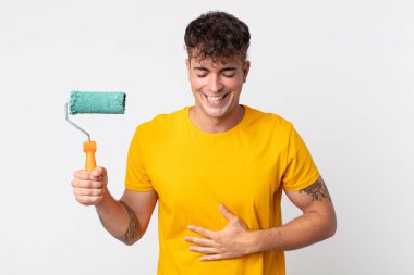 Genç yakışıklı bir adam komik bir şakaya yüksek sesle gülüyor. resim ev kavramı