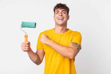 Genç yakışıklı adam kendini mutlu hissediyor ve bir meydan okumayla yüzleşiyor ya da kutluyor. resim ev kavramı