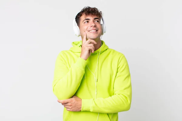 Jovem Bonito Homem Sorrindo Feliz Sonhando Acordado Duvidar Fones Ouvido — Fotografia de Stock