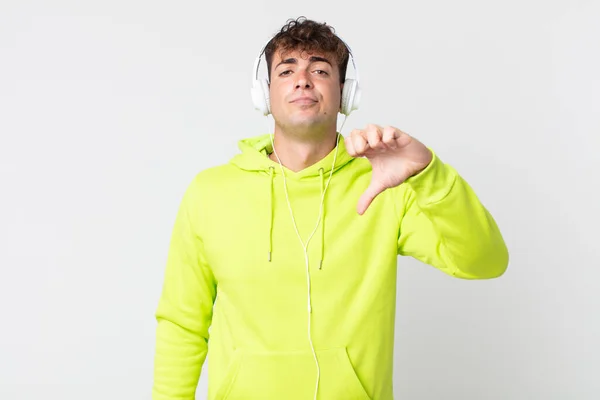 Jovem Homem Bonito Sentindo Cruz Mostrando Polegares Para Baixo Fones — Fotografia de Stock