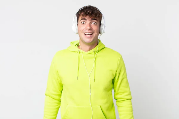 Mladý Pohledný Muž Vypadá Šťastný Příjemně Překvapený Sluchátka — Stock fotografie