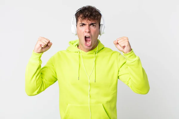 Jovem Bonito Homem Gritando Agressivamente Com Uma Expressão Irritada Fones — Fotografia de Stock