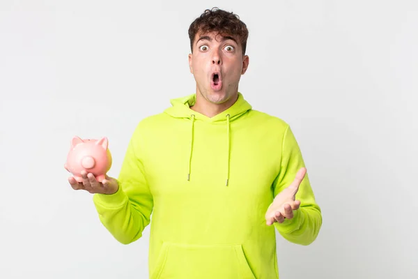 Young Handsome Man Amazed Shocked Astonished Unbelievable Surprise Holding Piggy — Stock Photo, Image