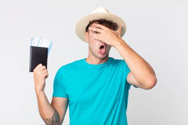 Genç, yakışıklı adam şok olmuş, korkmuş ya da korkmuş görünüyor. Elinde pasaportu olan bir yolcu.